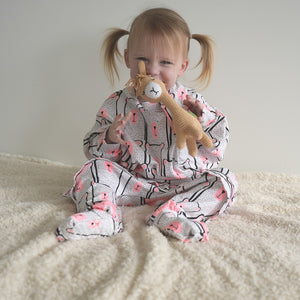 Toddler in onesie pajamas with pink bear pattern and zipper access for diaper changing