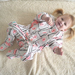 Toddler wearing a pink bear patterned sleep onesie with zipper access for easy diaper changing