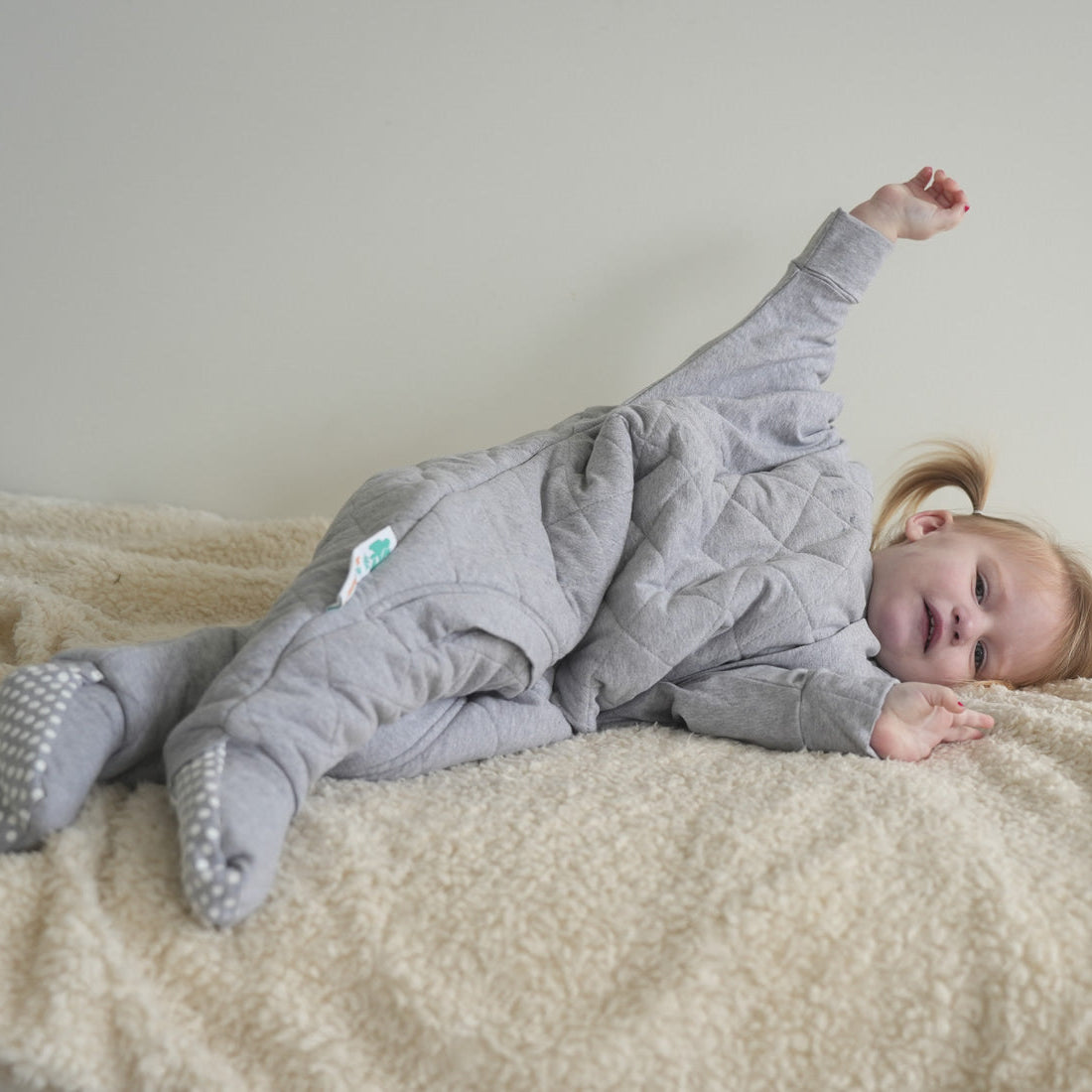 Sleepy toddler in a grey onesie looking warm and comfortable for winter sleep