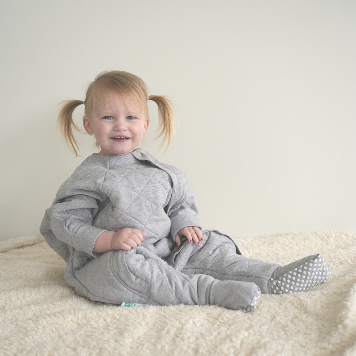 Toddler wearing a gray quilted sleep onesie for winter sleep
